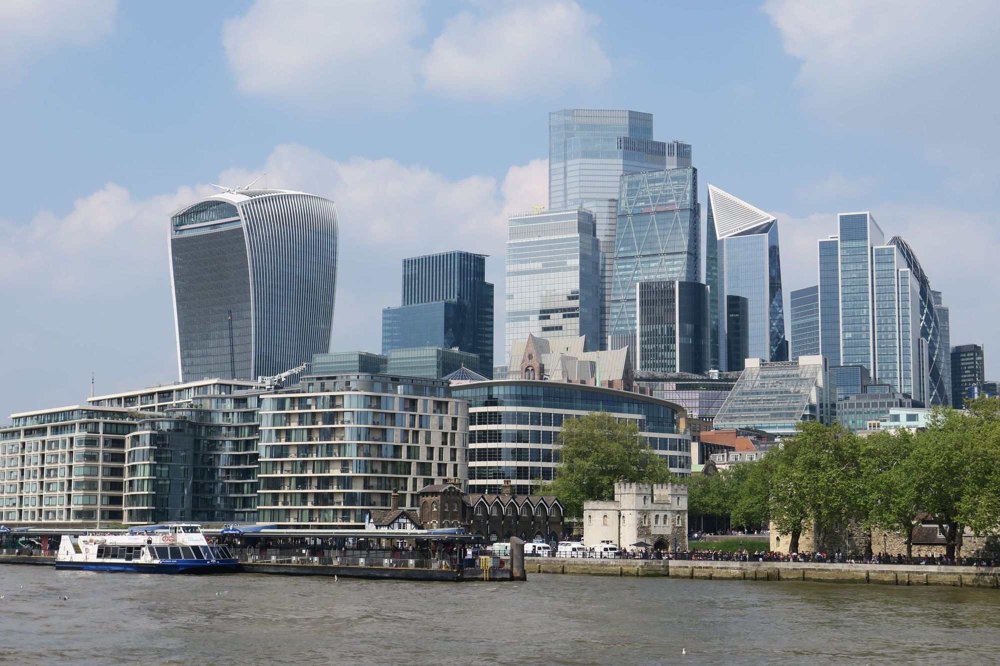 Skyscrapers of the City of London rising above the River Thames on a bright day