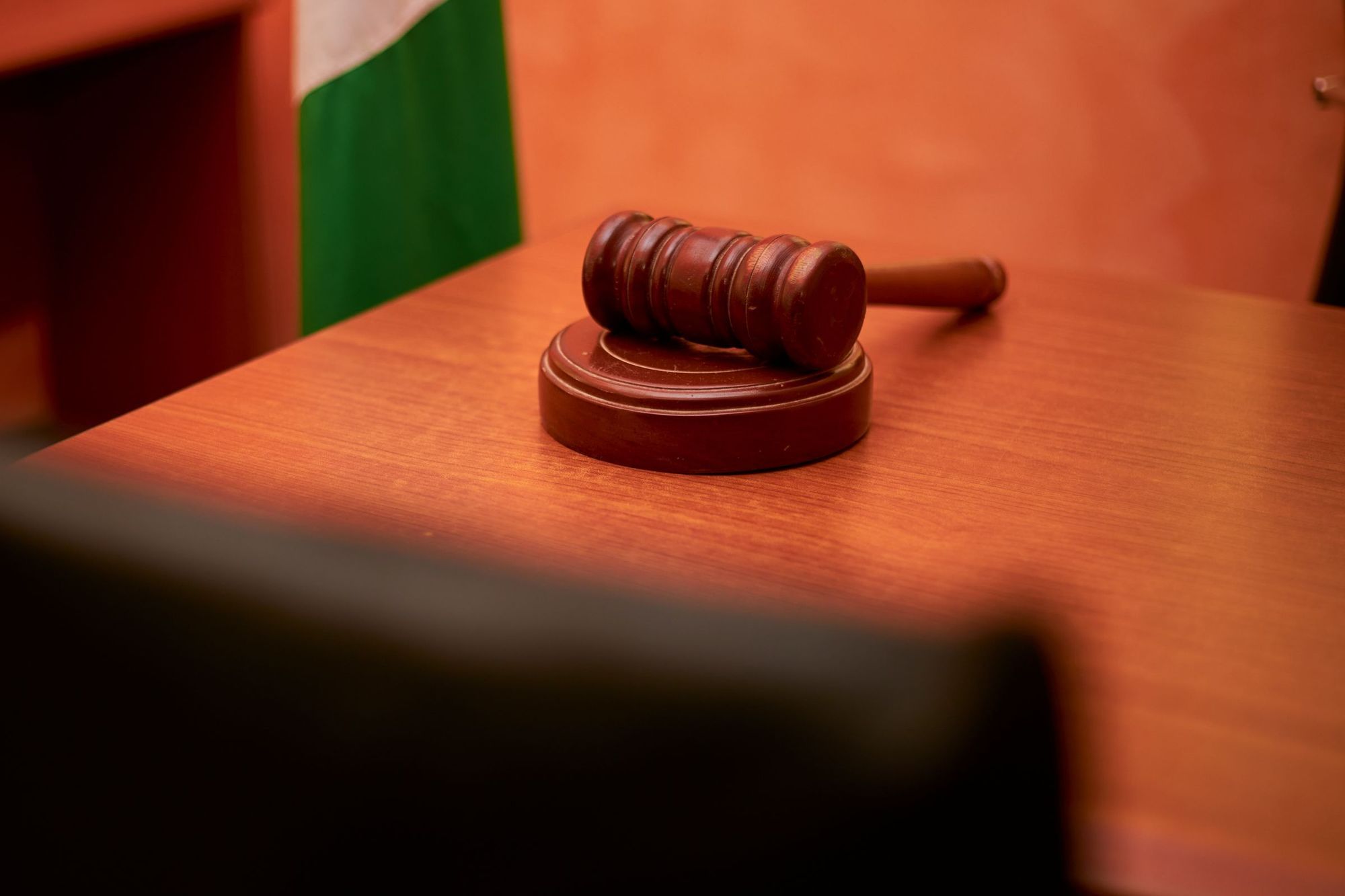 A gavel on a courtroom desk lit by warm light
