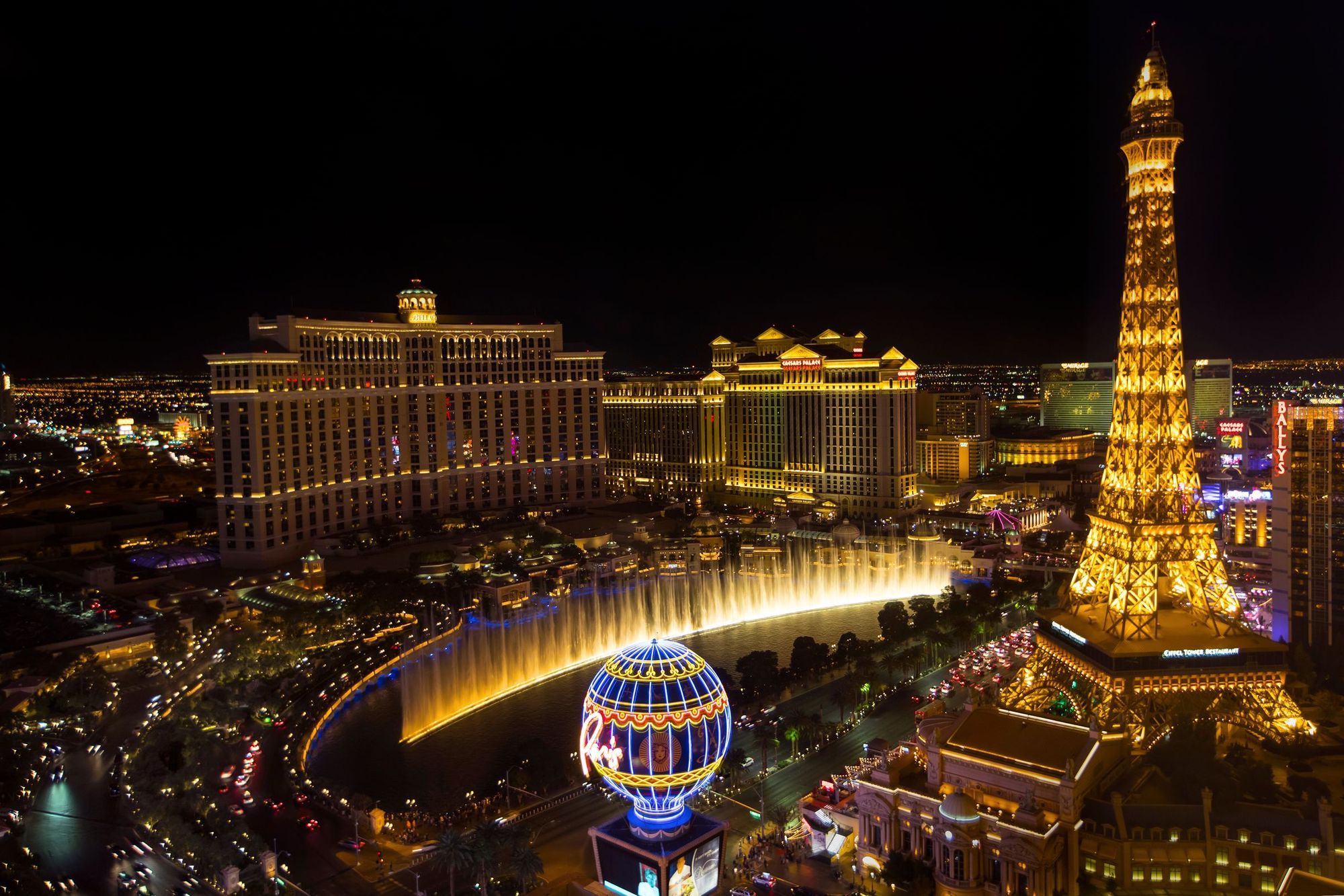 The Las Vegas Strip at night with the Bellagio fountains and the Eiffel Tower replica