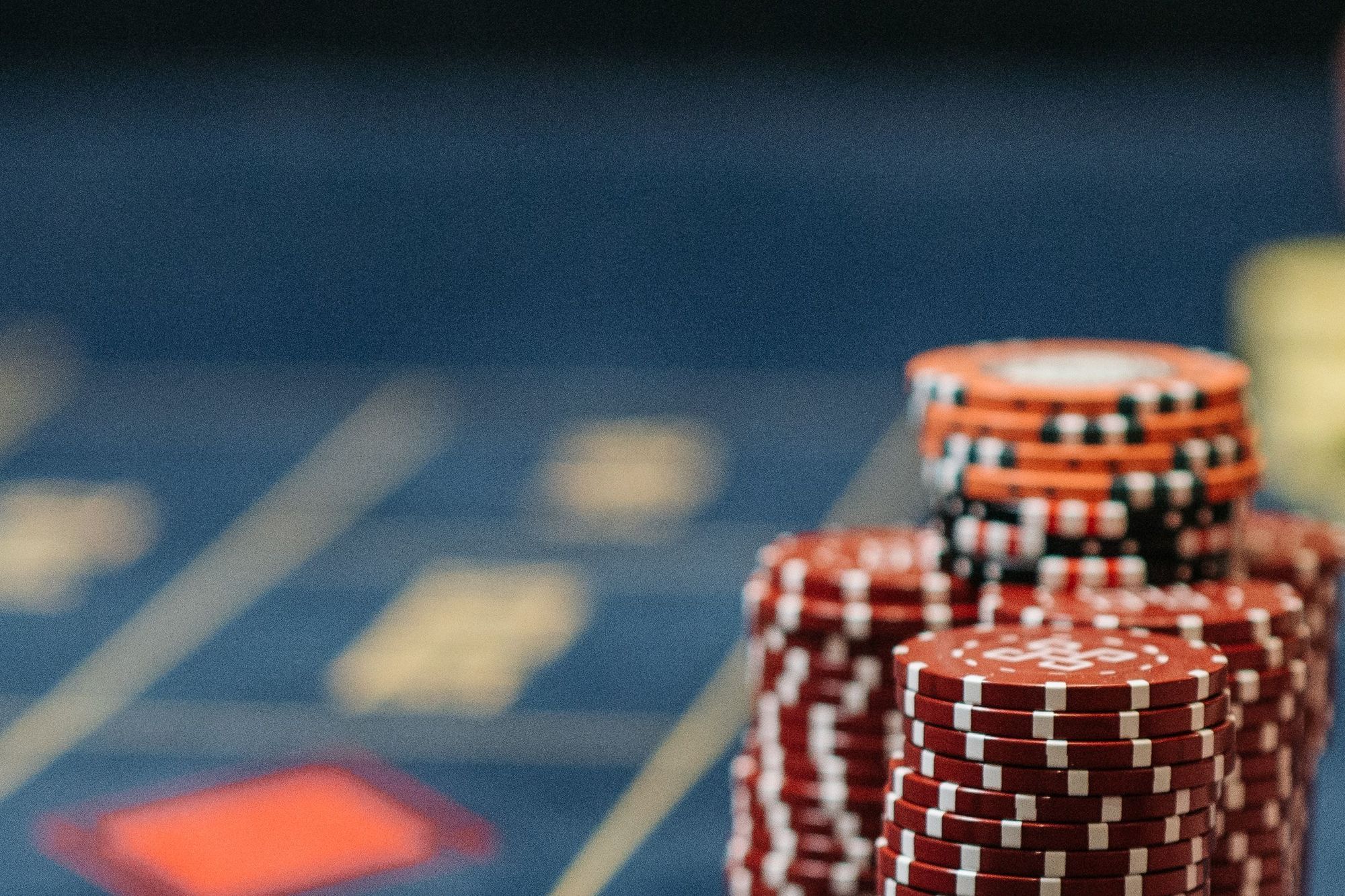Stacks of red casino chips on a blue gaming table